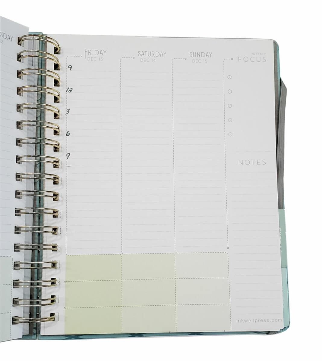 A spiral bound Inkwell Press Planner sits open to a weekend calendar page. The page is blank.