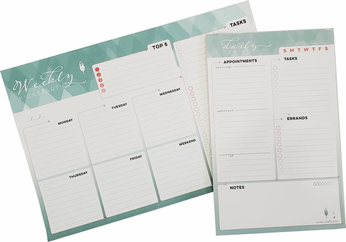 An inkwell Press weekly kickstarter planner lays facing up with an Inkwell daily docket placed on top of it. Both planners are blank