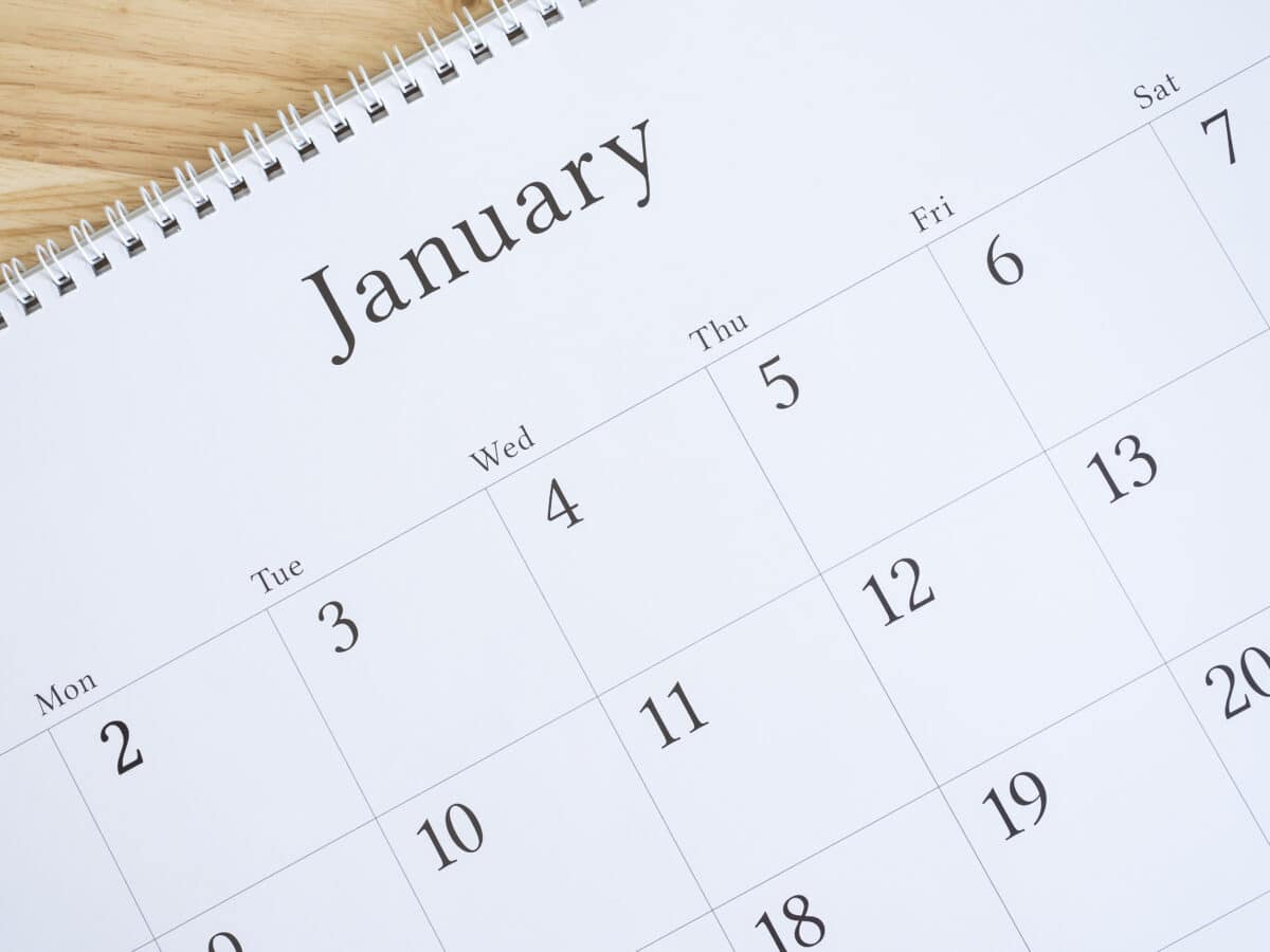 January on white calendar page, desk calendar on wood background