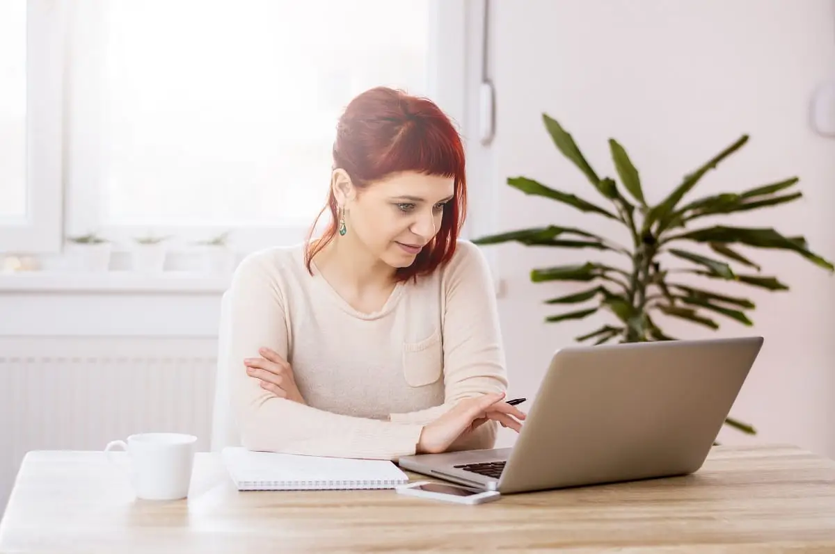 Young beautiful woman with red hair working in the office on writing blog headlines