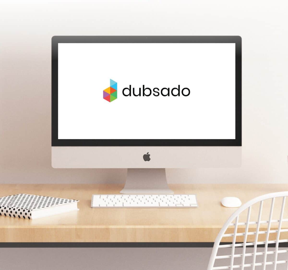 A computer on a desk with the Dubsado logo on the screen
