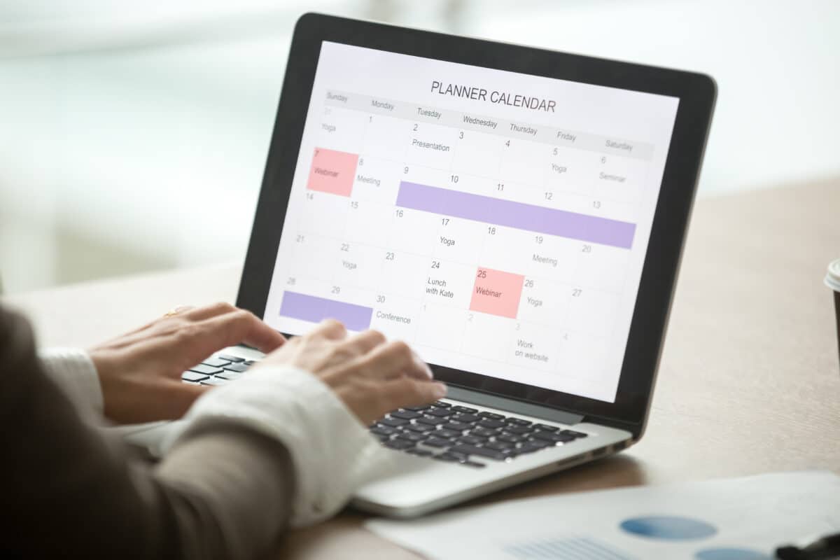 Woman using a planning calendar on a laptop computer